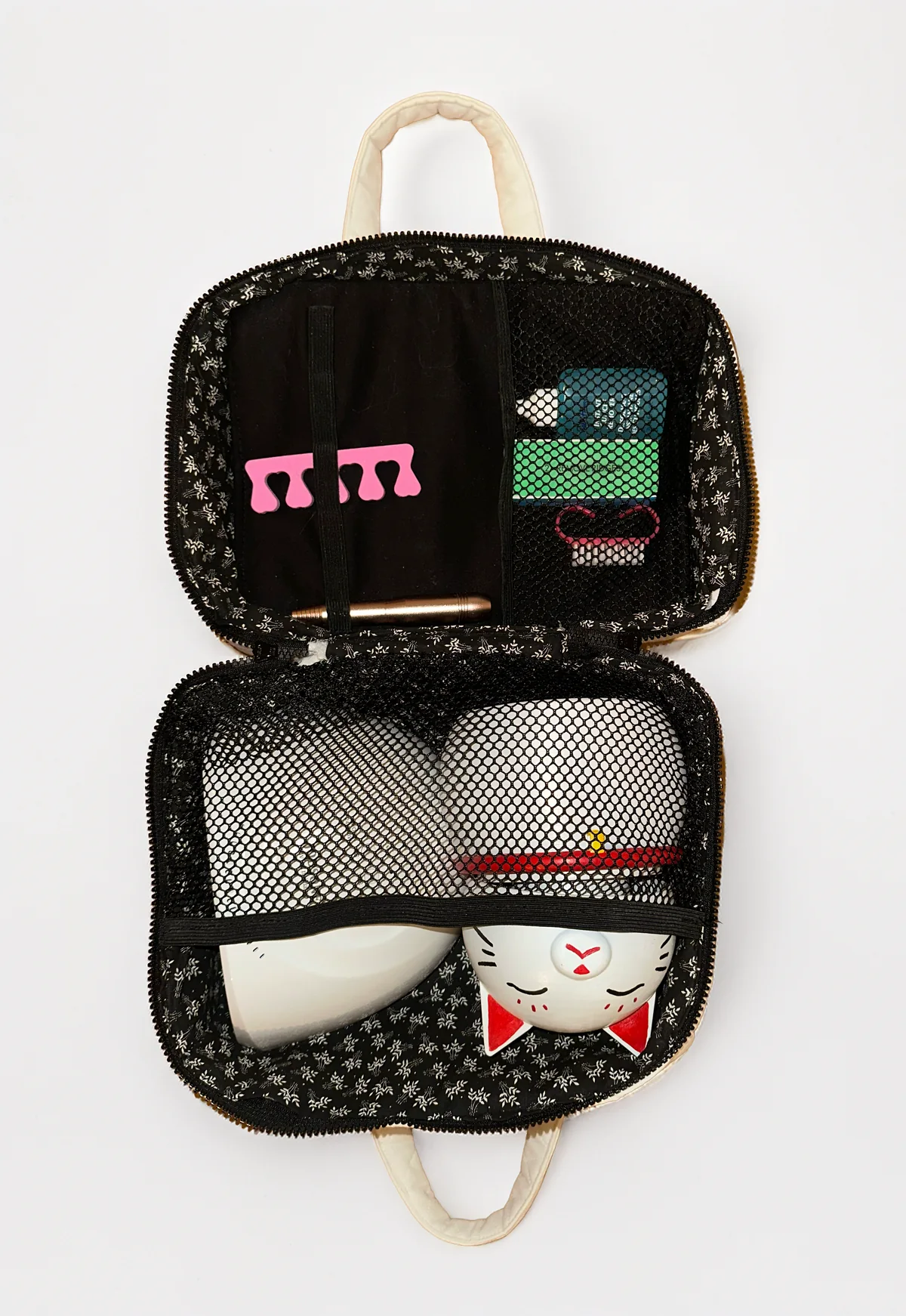 Bag open showing mesh pockets, nail tools, and the lucky cat diffuser